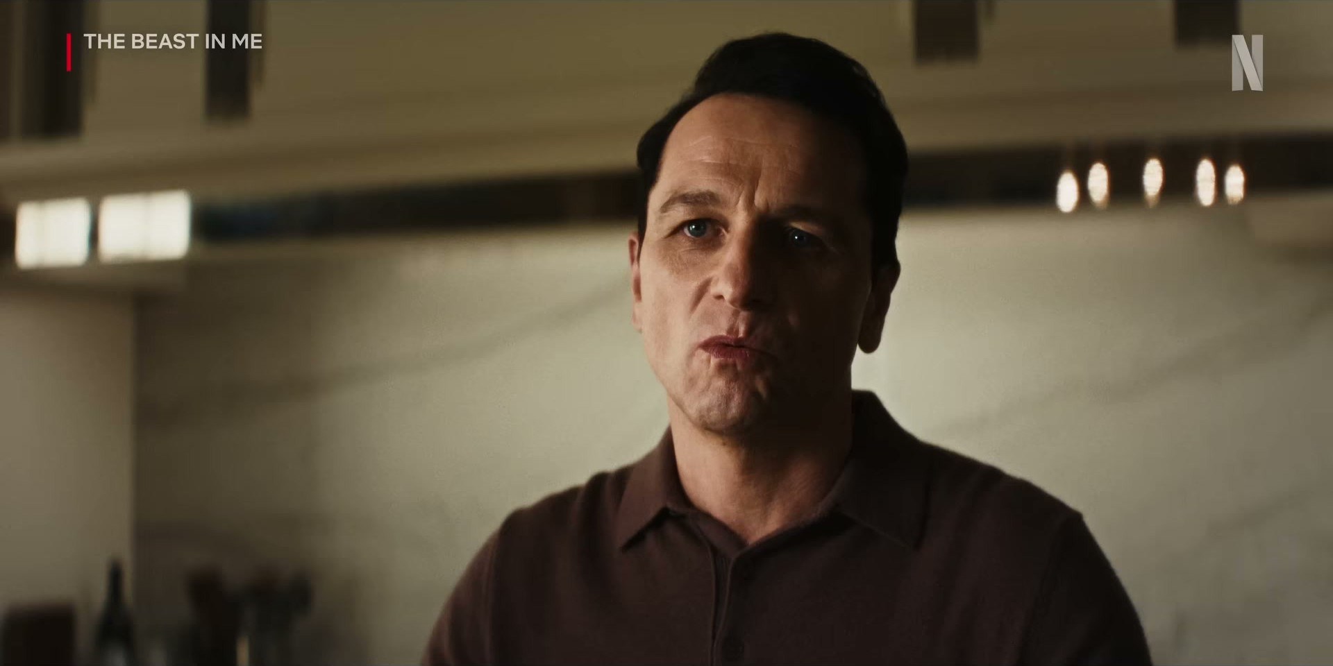 Matthew Rhys in The Beast in Me on Netflix — brown knit polos are actually the move