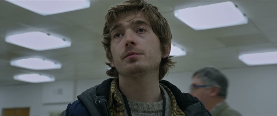 Austin Abrams in Resident Evil — the plaid scarf is honestly doing all the work here